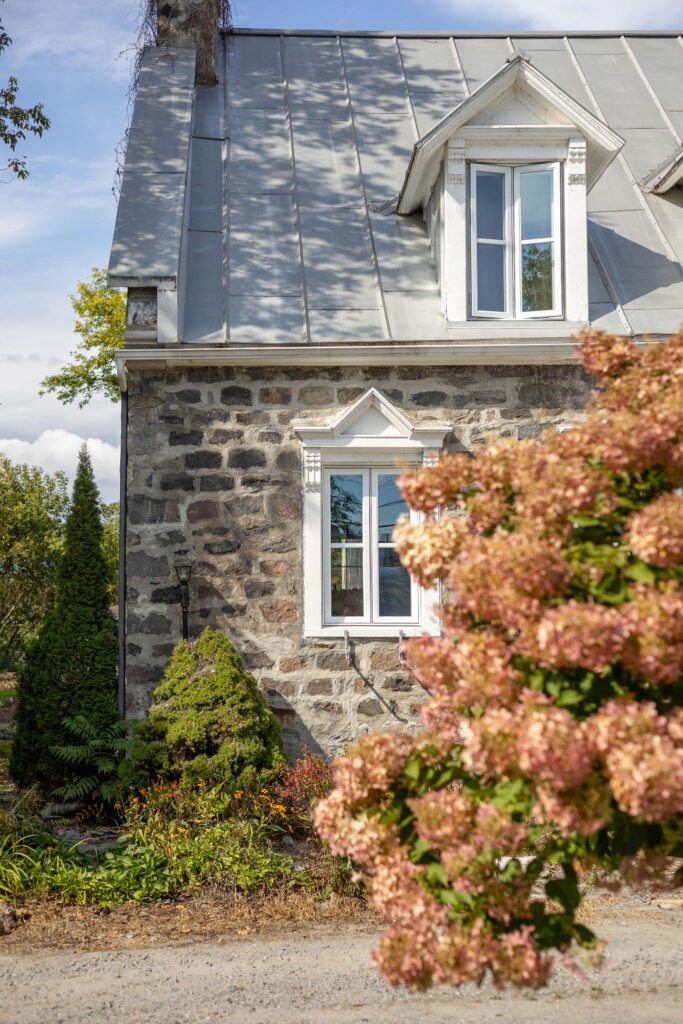 Stone facade of the Manoir with blooming hydrangeas