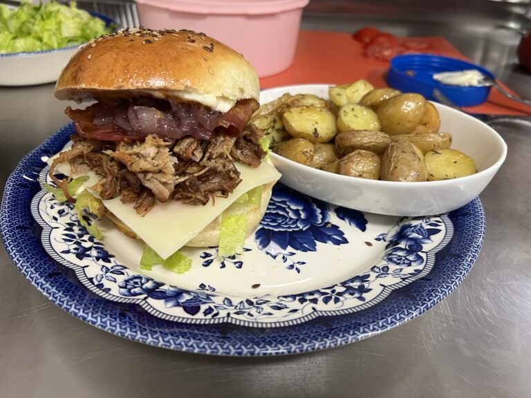 Burger served with potatoes on a plate.