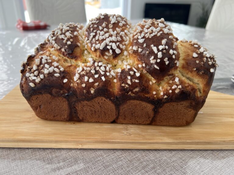 Golden sugar-topped brioche on a wooden board.